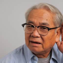 Man with hearing loss holds hand behind ear