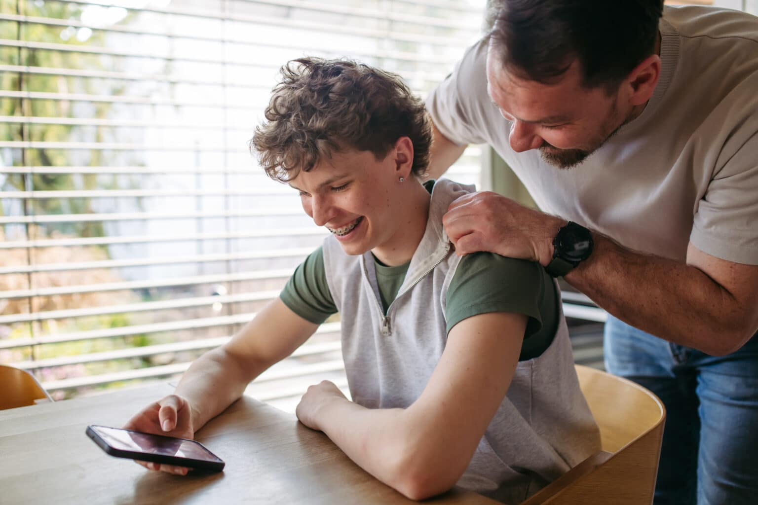 Happy parent and teen discuss safe listening habits for hearing health