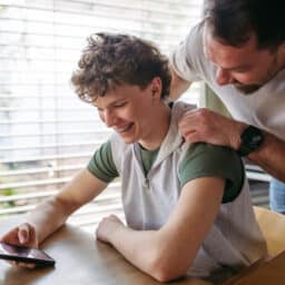 Happy parent and teen discuss safe listening habits for hearing health