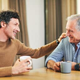 Father and his adult son having a heartfelt conversation.