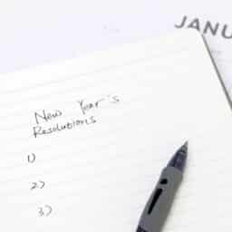 Close-up of a handwritten notebook page titled "New Year's Resolutions"; planning for new year.