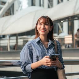 Confident woman on her phone in a trendy urban city.