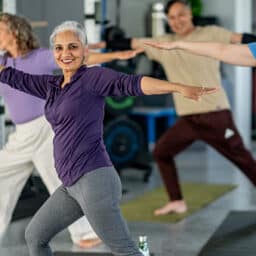 Woman smiles at the camera during a group tai chi class