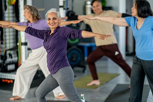 Woman smiles at the camera during a group tai chi class