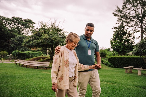 Balance specialist working with a patient walking outdoors to strengthen balance.